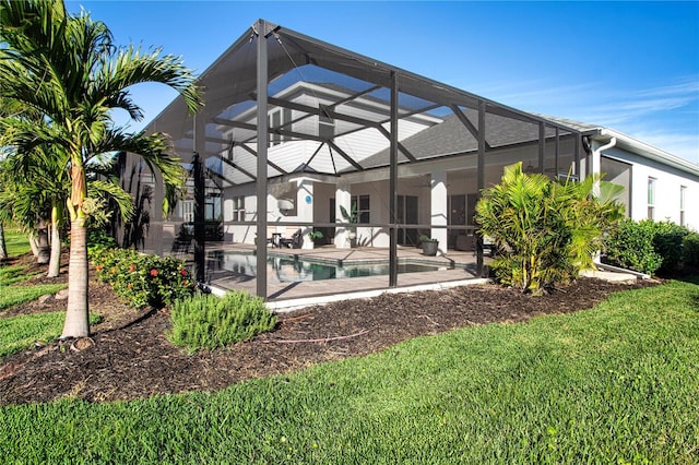 back of property featuring a lanai and a lawn