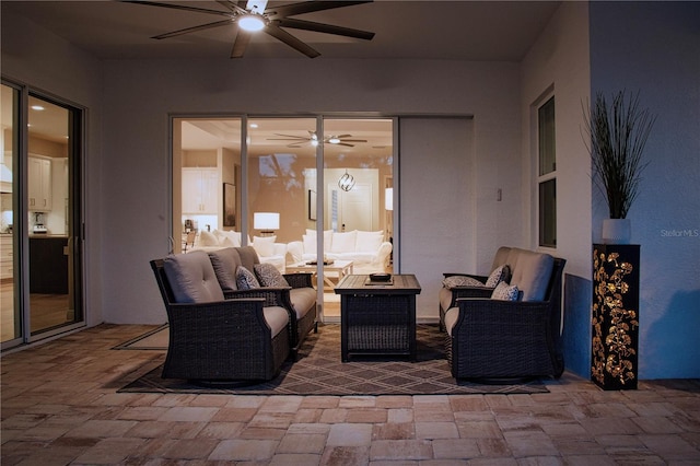 view of patio featuring ceiling fan and an outdoor living space with a fire pit