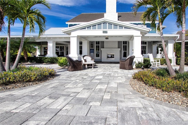 back of property with a patio and exterior fireplace