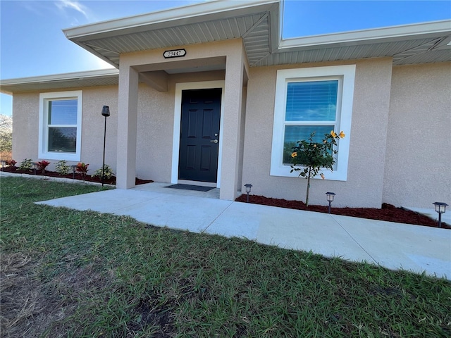 doorway to property with a lawn