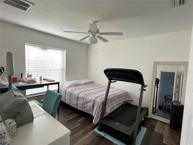 bedroom featuring multiple windows, dark hardwood / wood-style flooring, and ceiling fan