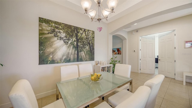 dining area with a chandelier and light tile patterned flooring