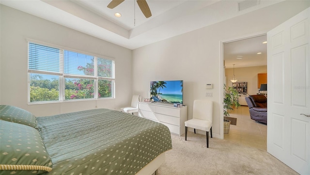 tiled bedroom with a tray ceiling and ceiling fan