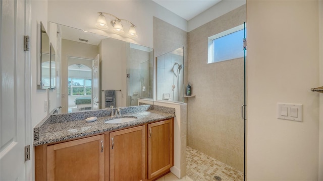 bathroom featuring a tile shower and vanity