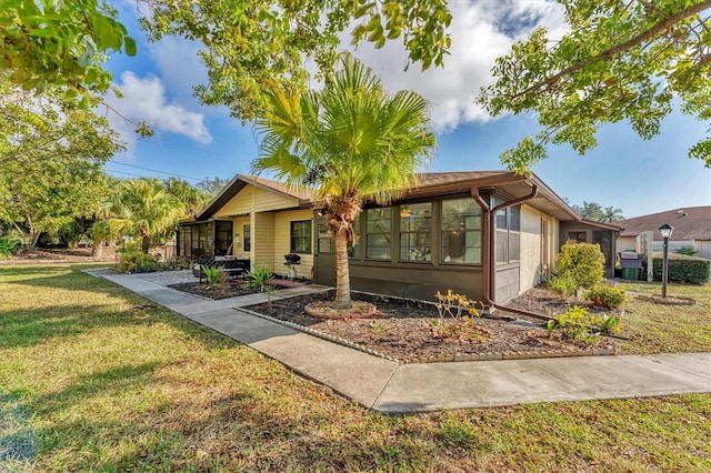 view of front of house featuring a front lawn and a sunroom