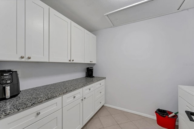 clothes washing area with light tile patterned floors