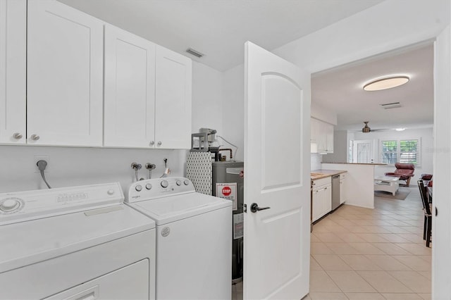 clothes washing area featuring cabinets, ceiling fan, water heater, washer and dryer, and light tile patterned floors