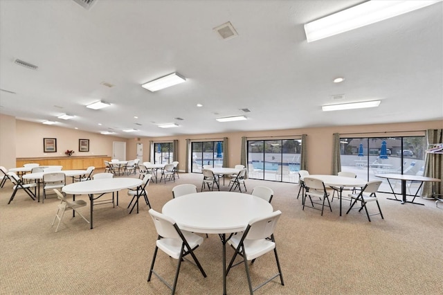 dining area featuring light carpet and lofted ceiling