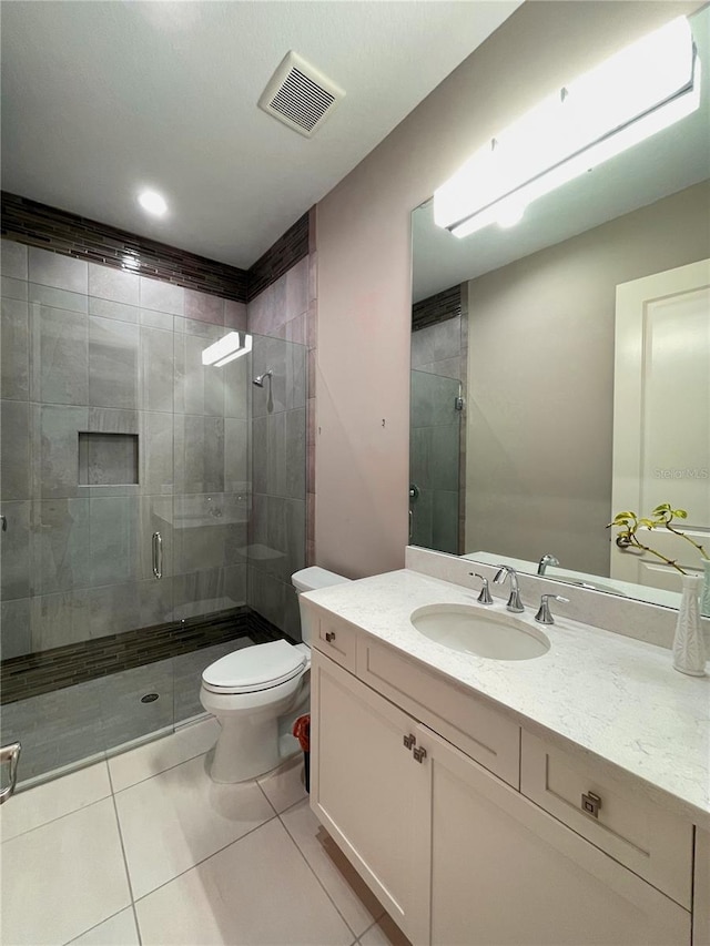 bathroom featuring tile patterned flooring, vanity, toilet, and an enclosed shower