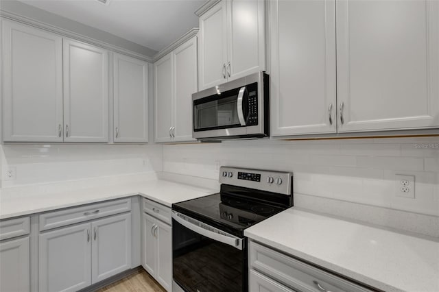 kitchen featuring appliances with stainless steel finishes, light countertops, and decorative backsplash