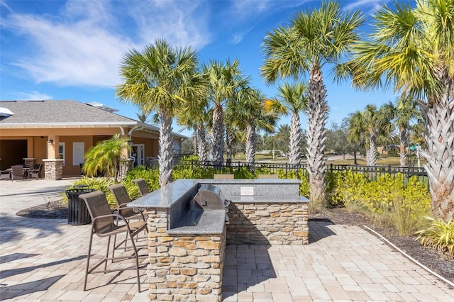 view of patio / terrace with fence, outdoor dry bar, and area for grilling