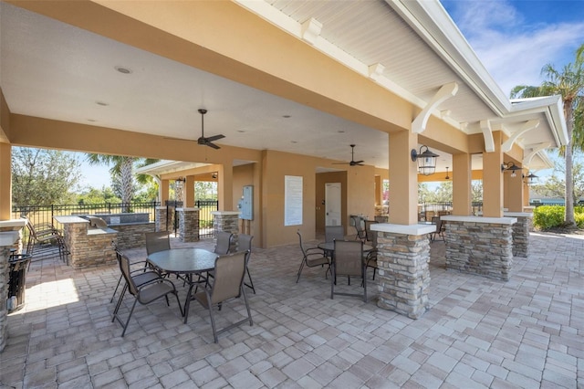 view of patio featuring outdoor dry bar, ceiling fan, outdoor dining space, and fence