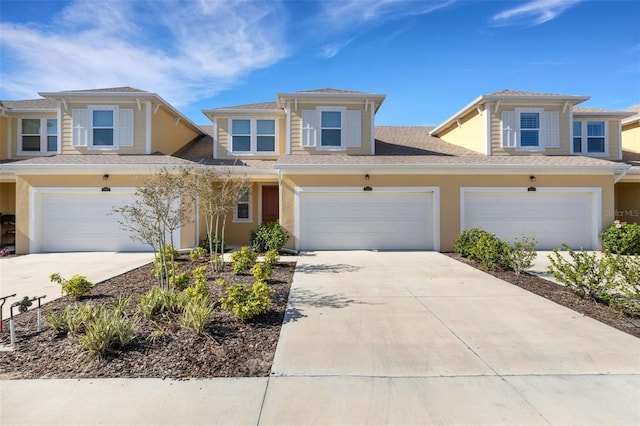 view of front facade featuring a garage, driveway, and stucco siding