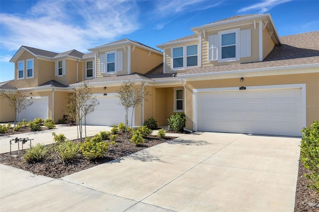 view of front facade featuring concrete driveway, an attached garage, and stucco siding