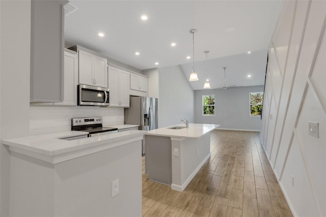 kitchen with a kitchen island with sink, stainless steel appliances, a sink, white cabinetry, and pendant lighting