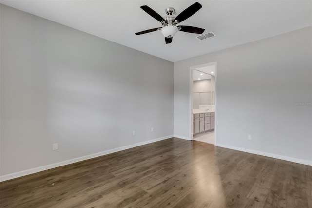 spare room featuring ceiling fan, wood finished floors, visible vents, and baseboards