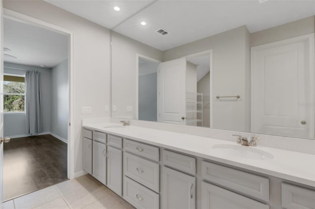 bathroom with double vanity, visible vents, a sink, and tile patterned floors