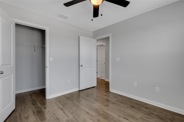 unfurnished bedroom featuring ceiling fan, light wood-style flooring, visible vents, baseboards, and a closet