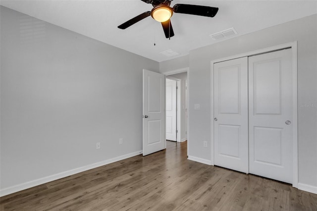 unfurnished bedroom with light wood finished floors, a closet, visible vents, a ceiling fan, and baseboards