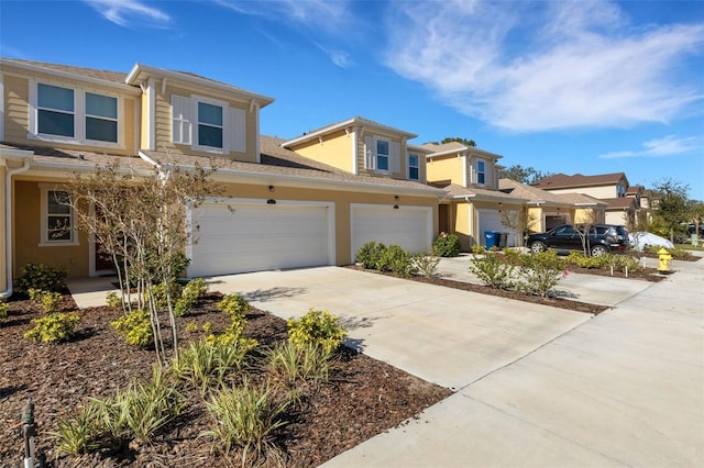 multi unit property featuring driveway, a garage, and stucco siding