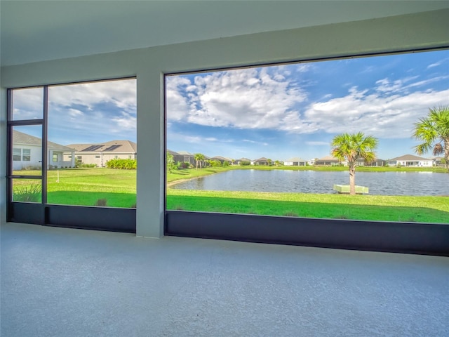 unfurnished sunroom featuring a water view and a residential view