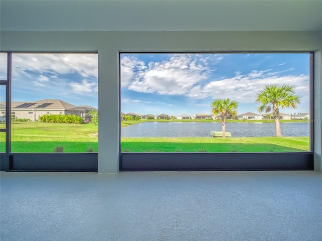 unfurnished sunroom with a wealth of natural light, a water view, and a residential view