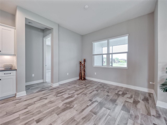 unfurnished room featuring light wood-style flooring and baseboards