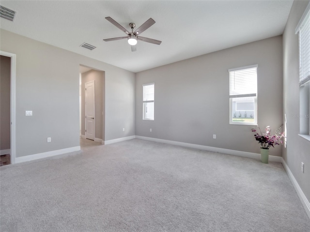 spare room featuring plenty of natural light, visible vents, and baseboards