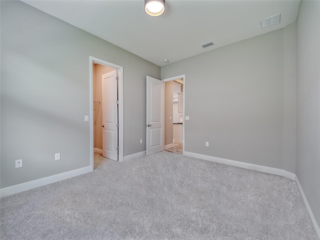 unfurnished bedroom featuring light carpet, visible vents, and baseboards