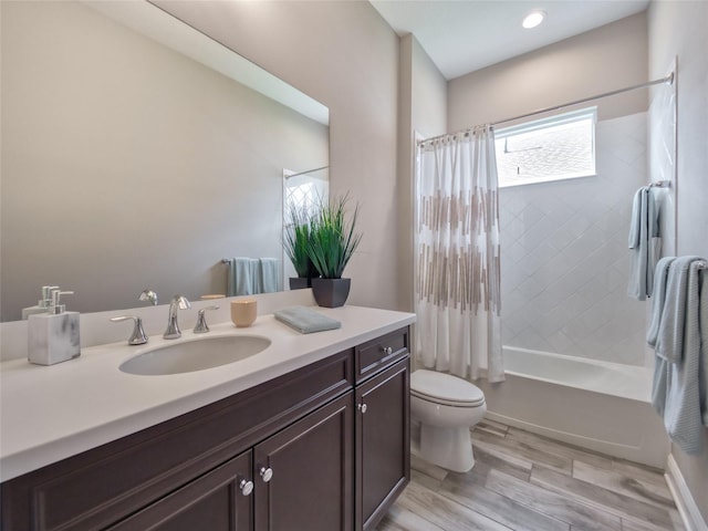 bathroom with toilet, wood finished floors, vanity, and shower / bathtub combination with curtain