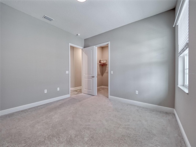 unfurnished bedroom with light carpet, baseboards, and visible vents