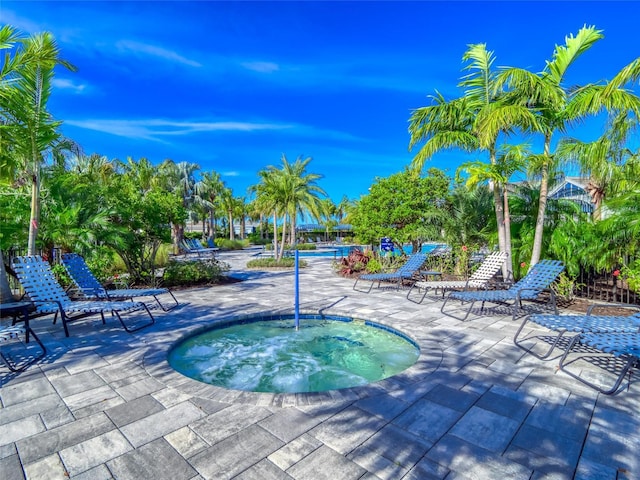 view of pool featuring a patio and a hot tub