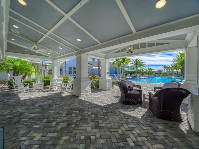 view of patio with a ceiling fan and an outdoor pool