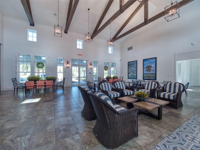 living area featuring beam ceiling, visible vents, and a healthy amount of sunlight