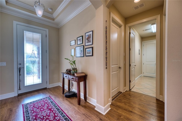 foyer with wood-type flooring and crown molding