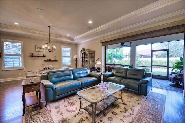 living room featuring hardwood / wood-style floors, a tray ceiling, plenty of natural light, and crown molding