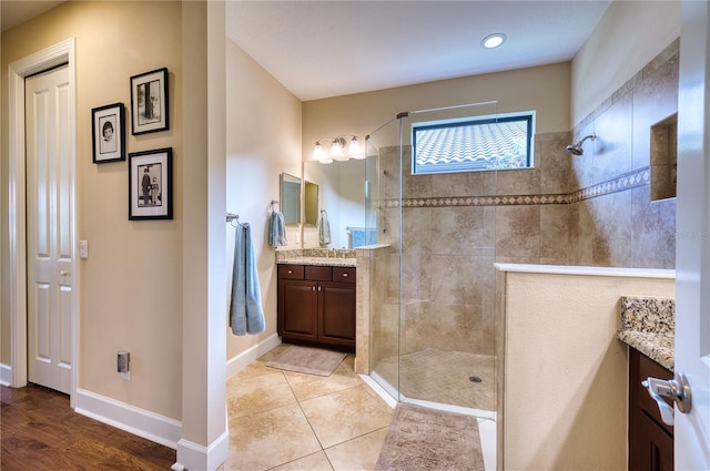 bathroom featuring tiled shower, vanity, and tile patterned floors