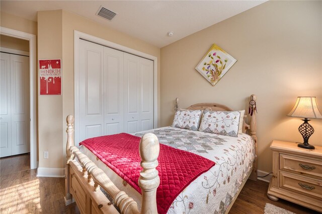 bedroom with dark hardwood / wood-style flooring and a closet