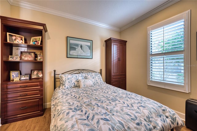 bedroom featuring ornamental molding and light hardwood / wood-style flooring