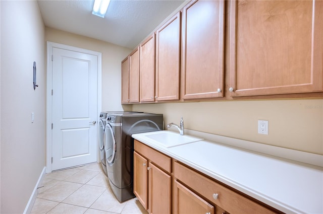 laundry area featuring cabinets, sink, washing machine and dryer, a textured ceiling, and light tile patterned flooring