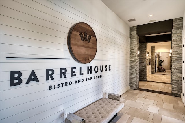 interior space featuring light tile patterned floors and wooden walls