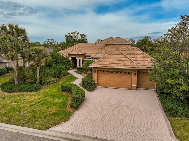 mediterranean / spanish house with a garage and a front lawn