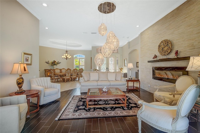 living room with a notable chandelier, ornamental molding, a fireplace, and french doors