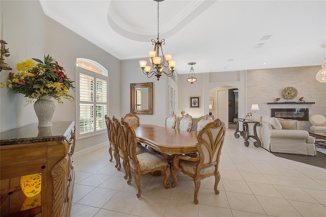 tiled dining area with a tray ceiling and an inviting chandelier