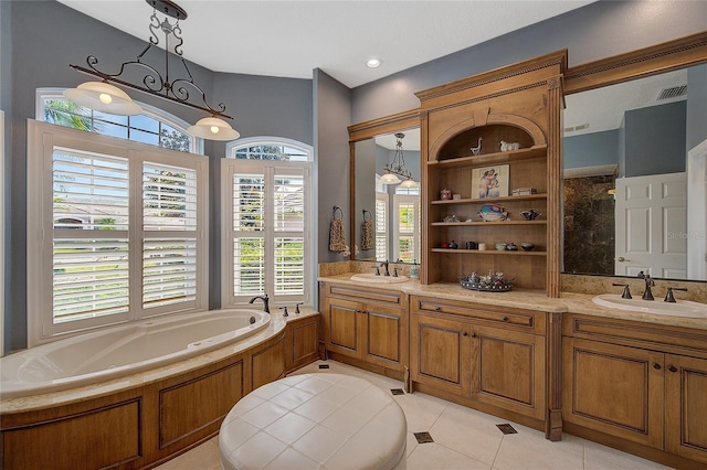 bathroom with tile patterned flooring, vanity, and a tub