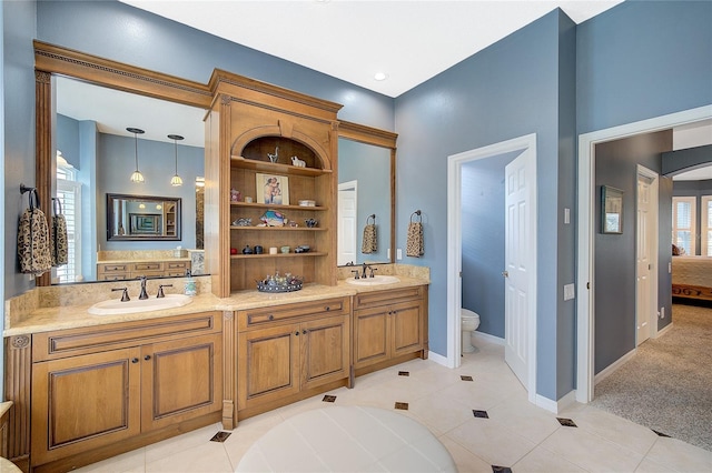 bathroom with tile patterned floors, vanity, toilet, and a wealth of natural light