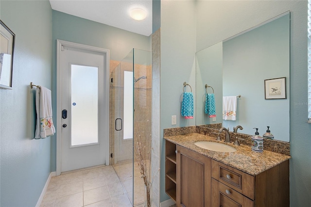 bathroom with tile patterned flooring, vanity, and a shower with door