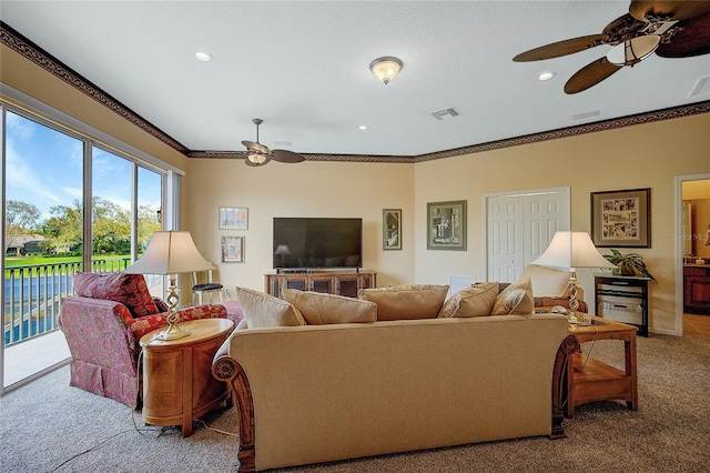 carpeted living room with ceiling fan and crown molding