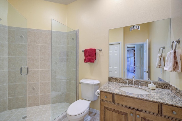 bathroom with vanity, toilet, and a shower with door