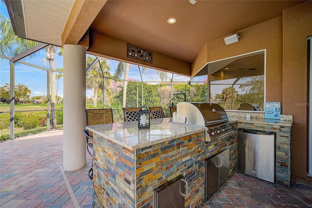 view of patio / terrace with area for grilling and a lanai